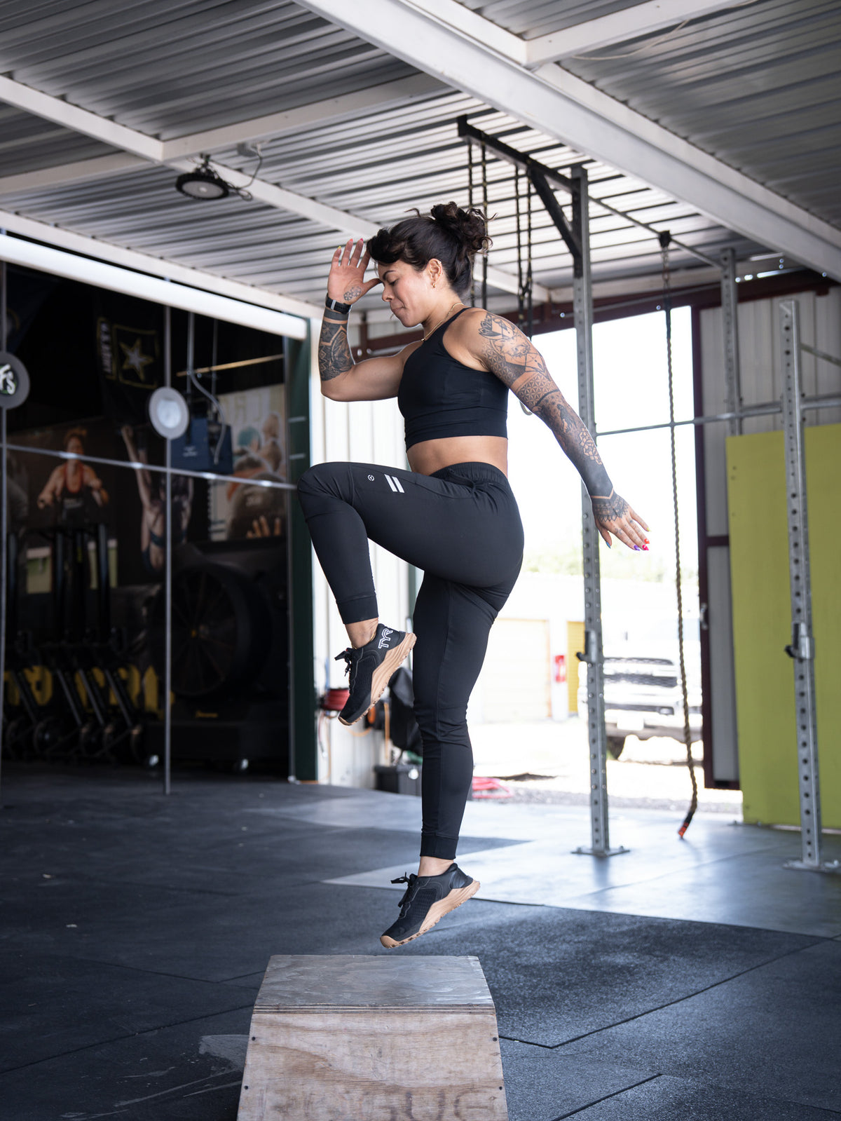 Female athlete in VIRUS® training gear jumping onto a box.